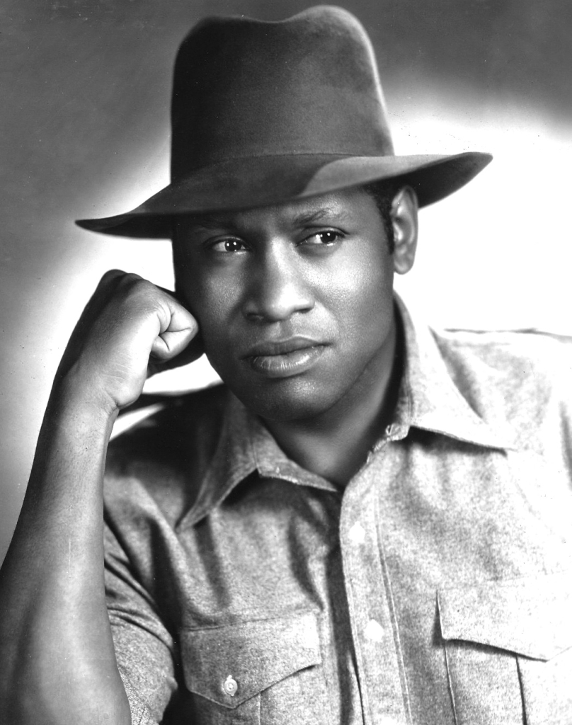 Sundance 2026: Kimberlé Crenshaw, Ava DuVernay, Viet Thanh Nguyen, and Jacqueline Stewart Confront Censorship and the New McCarthyism in The Story of Us 2 A black and white portrait of a man wearing a wide-brimmed hat and a collared shirt, resting his chin on his hand with a thoughtful expression.