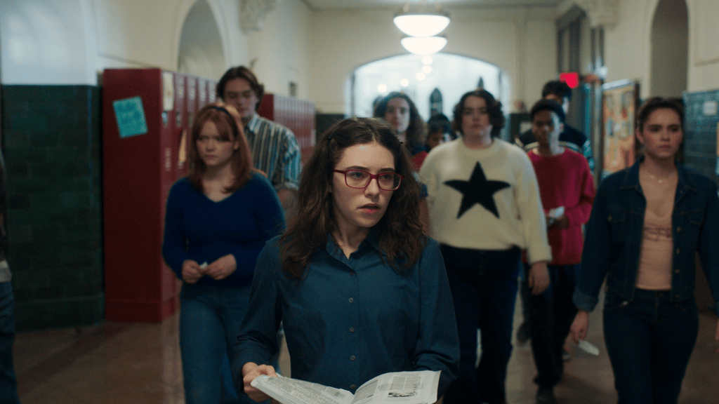 Free Expression and the Future of Film: ACLU Panel at Sundance 2026 3 A group of students walking through a school hallway, with one girl in the foreground wearing glasses and a blue shirt, holding a book. Other students follow closely behind in casual attire.